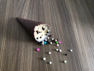 ice cream cone filled with dulce de leche, chocolate, brigadeiro, coconut on wooden background with 