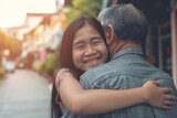 Fototapeta Londyn - asian teenage daughter hugging her father outside in town when spending time together