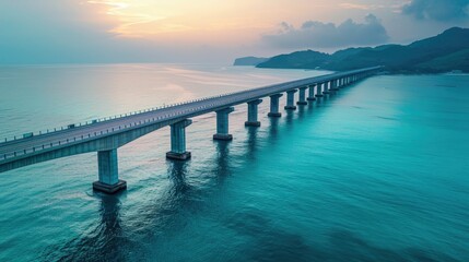 Wall Mural - aerial view of a long bridge crossing a tranquil blue sea at dawn
