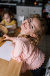 © Serena Burroughs/Stocksy - Happy girl with glasses drawing at her kitchen table at home