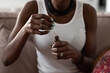 © Milles Studio/Stocksy - Crop black woman holding bottle with serum