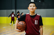© ZQZ Studio/Stocksy - Portrait of basketball boy standing in a gym