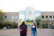 © Rob and Julia Campbell/Stocksy - Two female students walking and talking together on campus.