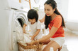 © Marc Tran/Stocksy - Mother and her daughter helping in the laundry room