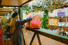 Woman Shopping In A Christmas Market Stall