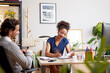 © ALTO IMAGES/Stocksy - Happy woman signing document during work with colleague