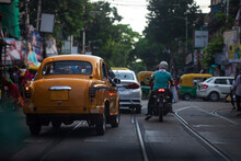 Cityscape Of Kolkata With Vintage Yellow Taxi And Other  Vehicles