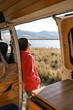 © Luis Herrera/Stocksy - woman enjoying nature traveling in camper van