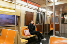 Cheerful Young Woman Sitting On Subway Train In New York