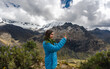 © Luis Herrera/Stocksy - Woman Enjoying the Snowy Mountains taking picture with  phone