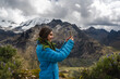 © Luis Herrera/Stocksy - Woman Enjoying the Snowy Mountains taking picture with  phone