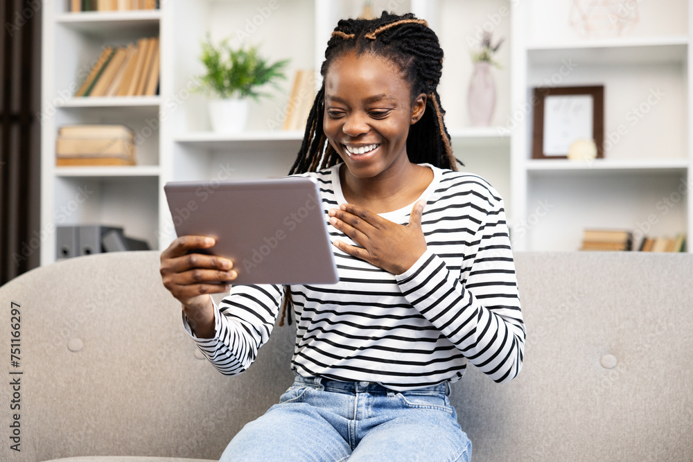 Smiling African American woman using a tablet for a video call while ...
