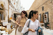 © Pedro Merino/Stocksy - Women visiting an Arab city, looking at the street stalls.