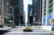 © David Prado/Stocksy - Car on asphalt road by high rise buildings in downtown