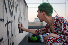Subversive Man With Colorful Hair Spray-painting Public Space