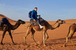 © Edward Córdoba / Andréas Sichel/Stocksy - Joyful tourist explores the desert on a guided camel tour.