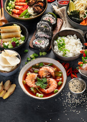 Sticker - Traditional Asian food table. Spring roll, rice, shrimp, sushi, vegetables, meat on dark background