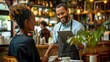 Happy waiter holding tablet with woman while taking her order in cafe.