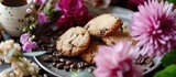 A closeup shot of a tray on a table, showcasing a plate of biscotti cookies, a cup of coffee, eustoma flowers, and coffee beans.