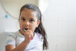 © Katherine Monge/Stocksy - Girl brushing her teeth