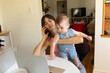 © Jordana Sheara/Stocksy - Mom multitasking with baby, computer and talking on the phone
