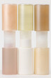 © Nicole Mason/Stocksy - symmetrical stack of beauty packaging in warm pastel tones