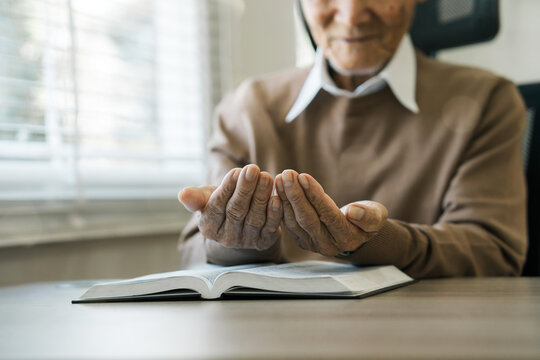 Grandfather sat and prayed to God on the window sill. Christian approaches to solitary worship Healing a peaceful life with God and the Holy Word