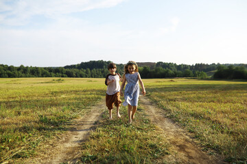 Wall Mural - Children walk in the summer in nature. Child on a sunny spring morning in the park. Traveling with children.