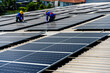 © Jack Tamrong - Two solar roof engineer men working on height installing solar panels on factory building roof