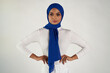 © Lauren Justice/Stocksy - Studio portrait of woman in blue headscarf and white top