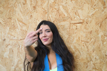 Young and beautiful brunette woman after a workout in the gym. The woman makes the fuck you sign with her middle finger. Camera focus on face.