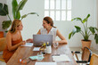 © BONNINSTUDIO/Stocksy - Female coworkers working on project in a beautiful office