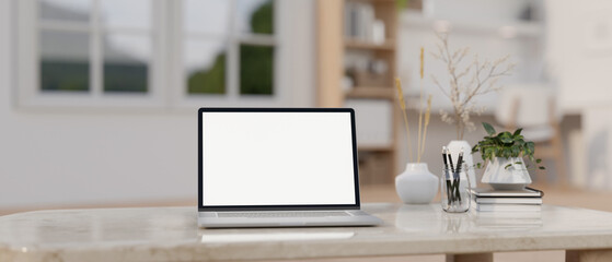 Home workspace, a white-screen laptop computer on a marble coffee table in a comfortable living room