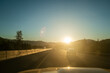 © David Keller/Stocksy - A glaring sunny view from the road