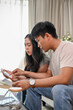 © bongkarn - A lovely young Asian couple is planning their savings and managing their household bills together.