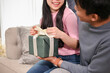 © bongkarn - A lovely Asian husband surprises his beloved wife by giving a present gift box.