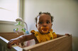 © Edward Córdoba / Andréas Sichel/Stocksy - A baby toddler girl holding herself up while inside her crip