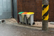 © SIYUN YUH/Stocksy - Colorful trash bins with heavy rain on the street