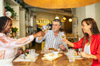 © Pedro Merino/Stocksy - Toast of three friends at a restaurant.