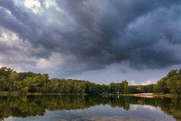 Wall Mural - Natural landscape of the lake, high definition, the movement of waves against the background of the autumn forest. The reflection of clouds on the ripples of water. Germany.