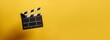 Clapperboard, movie slate, used in film production and cinema, movies industry isolated over bright yellow background