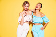 © halayalex - Two young beautiful smiling brunette hipster female in trendy summer clothes. Sexy carefree women posing near yellow wall in studio. Positive models having fun. Cheerful and happy