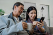 © itchaznong - Smiling caucasian senior elderly couple grandparent using mobile together