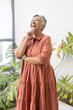 © Wavebreak Media - Senior biracial woman with short gray hair, wearing a coral dress, laughs joyfully