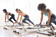© Wavebreak Media - Diverse women engage in a Pilates class at a fitness studio on reformers
