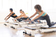 © Wavebreak Media - Women engage in a Pilates workout at a fitness studio on reformers