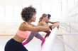 © Wavebreak Media - Diverse group of women practicing ballet exercises at a barre in a bright dance studio