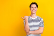 Portrait of toothy beaming guy wear stylish t-shirt indicating at proposition empty space isolated on vibrant yellow color background