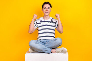 Canvas Print - Photo of cheerful lucky man wear striped t-shirt yelling yes rising fists isolated yellow color background