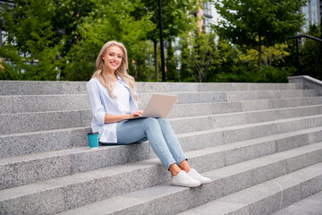 Canvas Print - Full body length photo of attractive cheerful blonde curls hair woman student sitting stairs studying remote online with computer